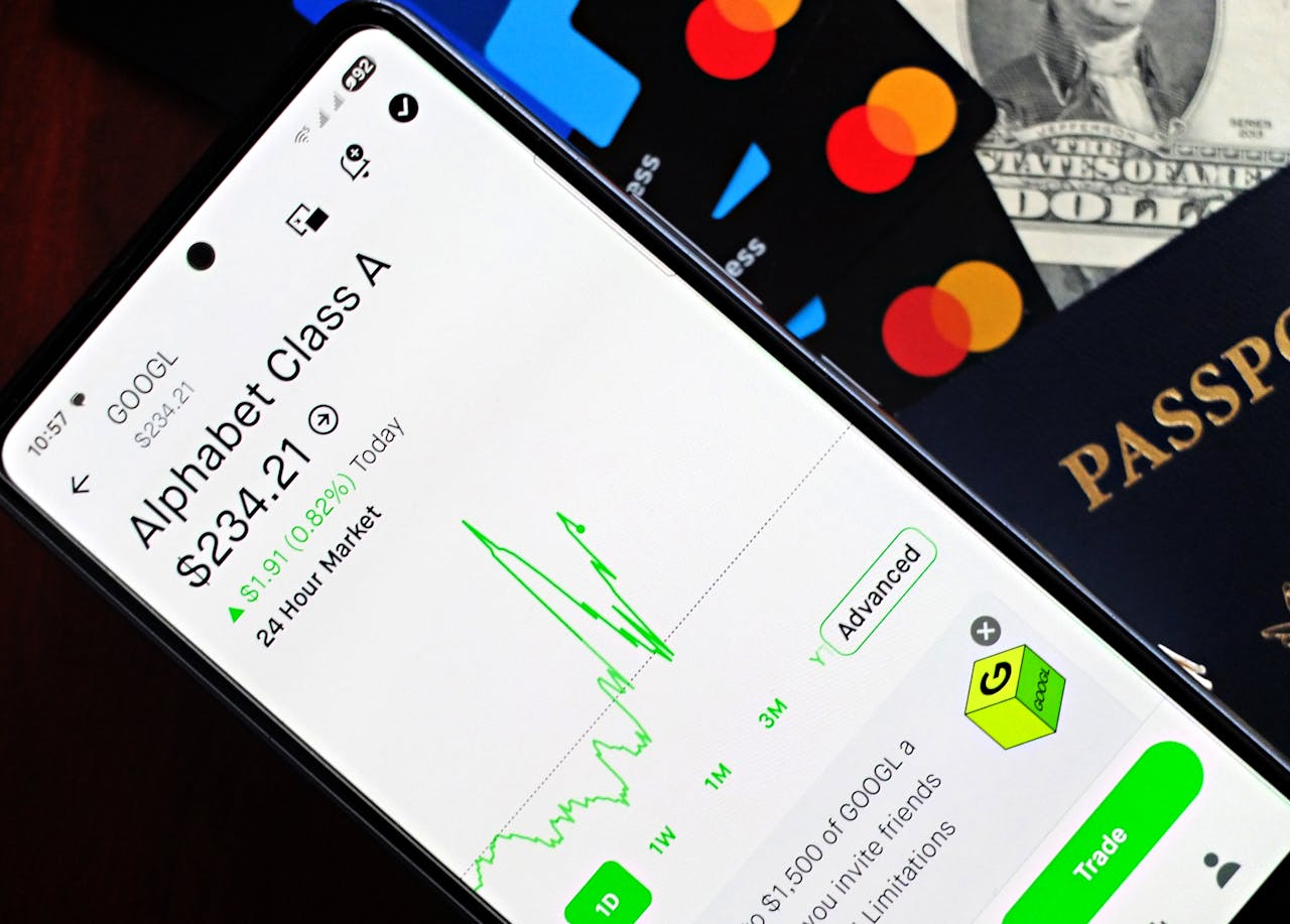 Smartphone displaying stock market app next to U.S. dollar and passport, representing global finance.
